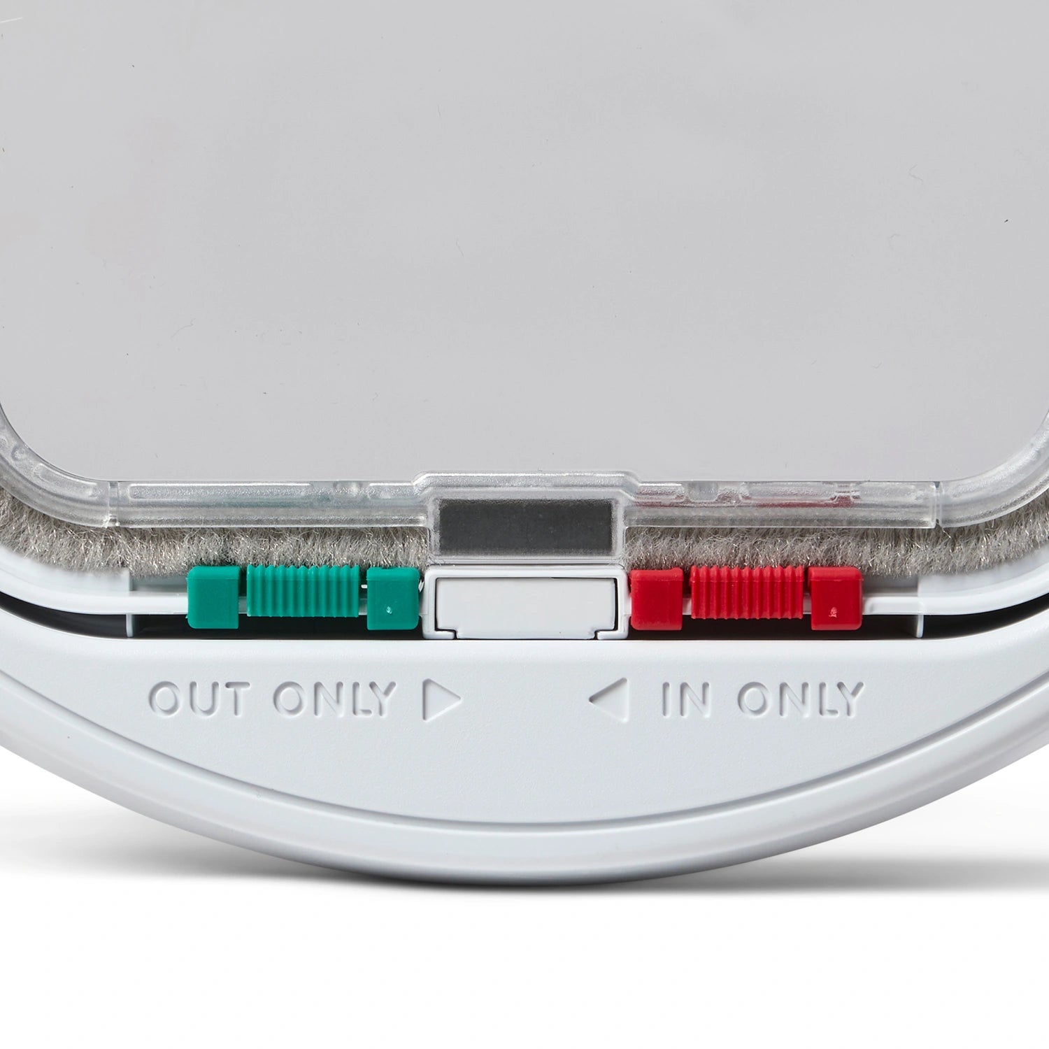 Close-up of the bottom part of the white cat flap with 'OUT ONLY' and 'IN ONLY' labels below the green and red manual locks on a white background