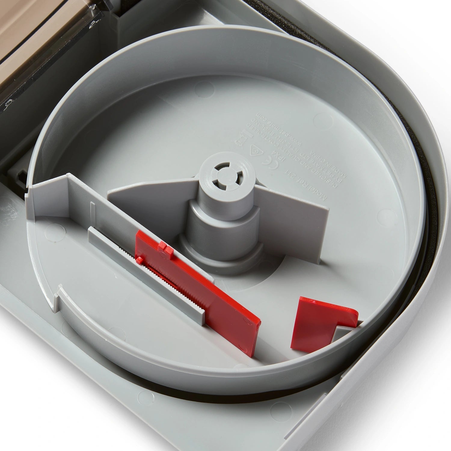 A close up view of the inside of the 21 day automatic pond fish feeder which is grey, with the red food baffle and portion control sizer at the bottom of the device, on a white background