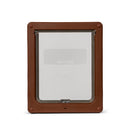 A brown pet door with a clear flap which is suitable for installation into doors and walls as it is self-lining up to two inches thick and can be used by cats and medium size dogs such as spaniels, on a white background