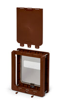 A composite view of the brown medium pet door with a clear coloured  access flap for cats and medium size dogs, with the brown locking panel placed above the flap to demonstrate its function when activated, on a white background
