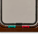 Close up view of the bottom of the brwn cat flap which displays the red and green locks, as well as the 'Out Only' and 'In Only' labels underneath, on a white background