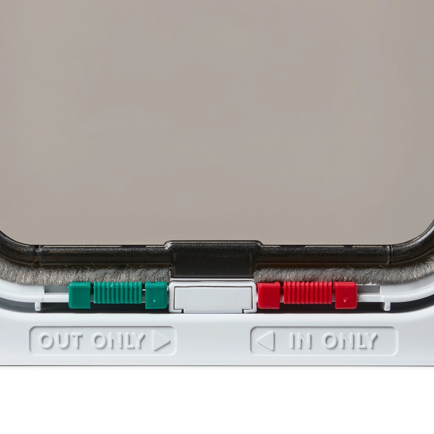 Close-up of a white cat flap with 'OUT ONLY' and 'IN ONLY' labels on a gray background
