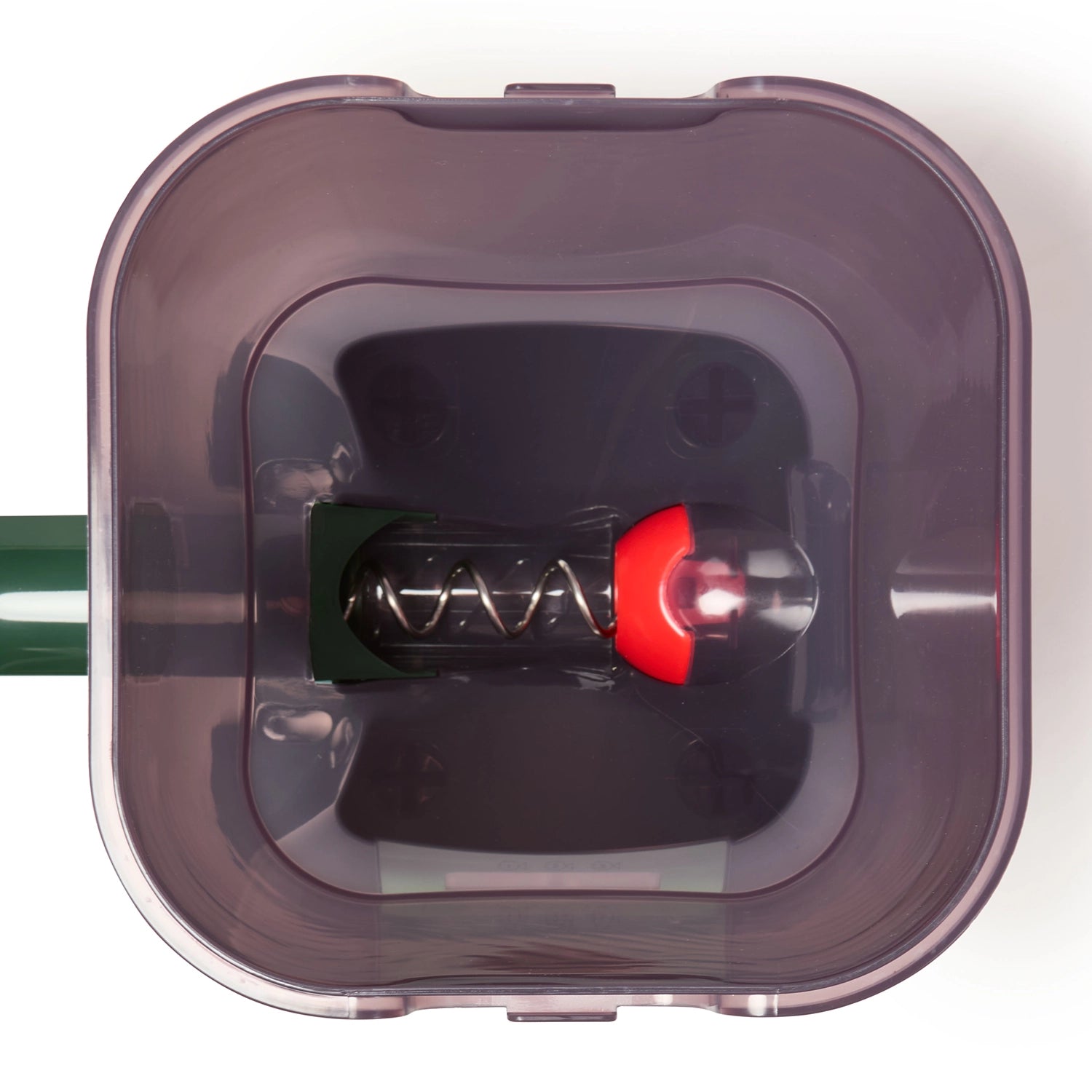 A close up view of the inside of the pond food container, with the spring and food chute visible, on a white background