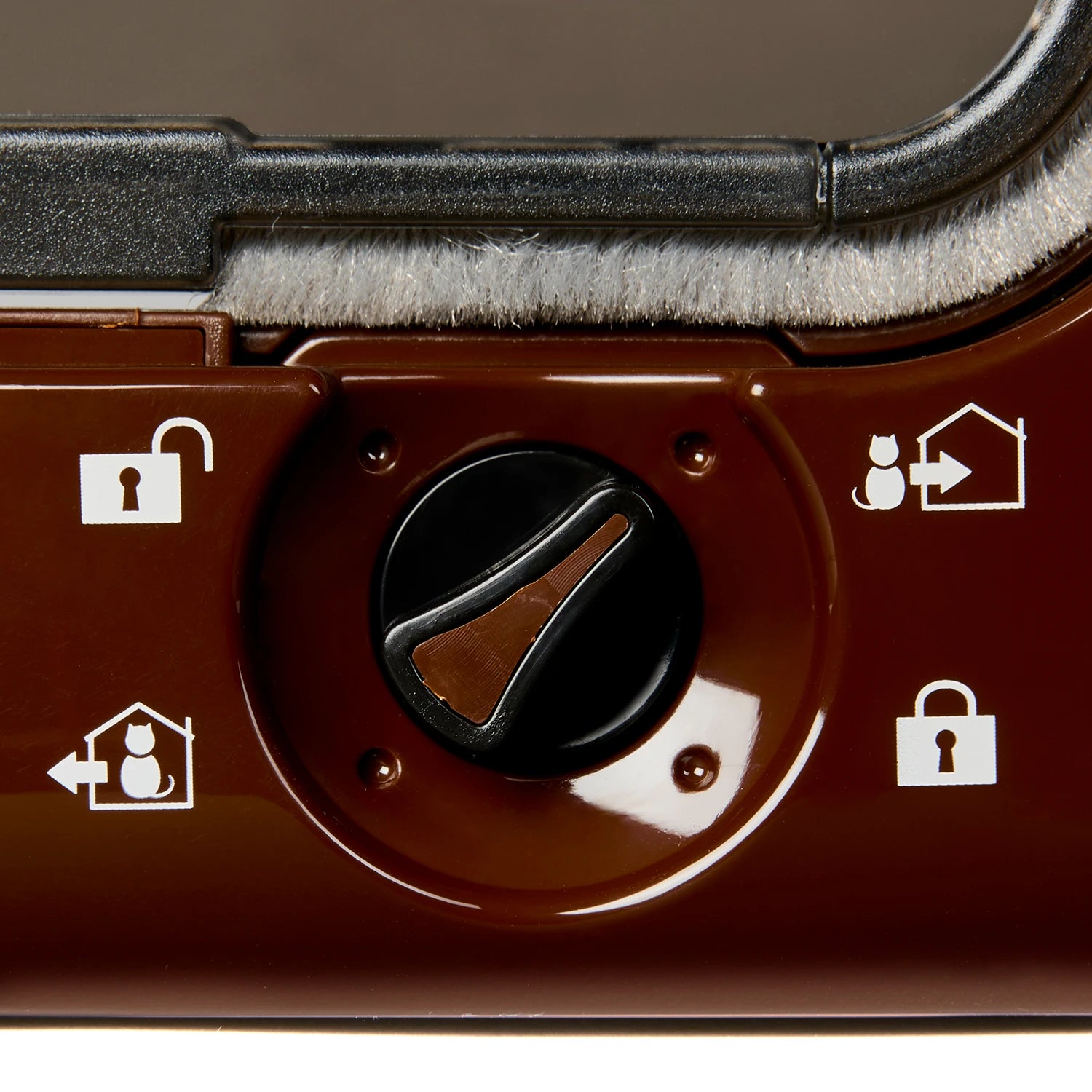Close-up of a brown, black and white control dial on a brown cat flap with a magnetic closure with rain proof and draught proof brushing