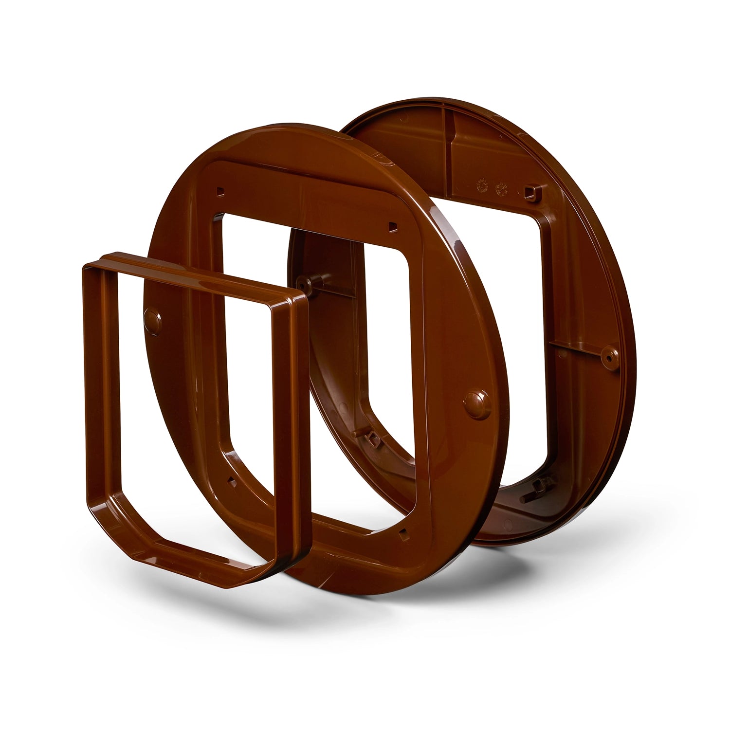 Three pieces of the brown cat flap adapter which allows for installation in to glass doors.