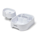 The white Dog Mate drinking fountain has been split in to two sections, showing the inside of the bottom tier, which includes the filter housing on a white background