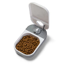 Pet food container with an open lid and a quartz twenty four hour timer on a white background