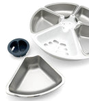 A stainless steel bowl insert is next to a white carousel dish containing the other four stainless steel dish inserts on a white background