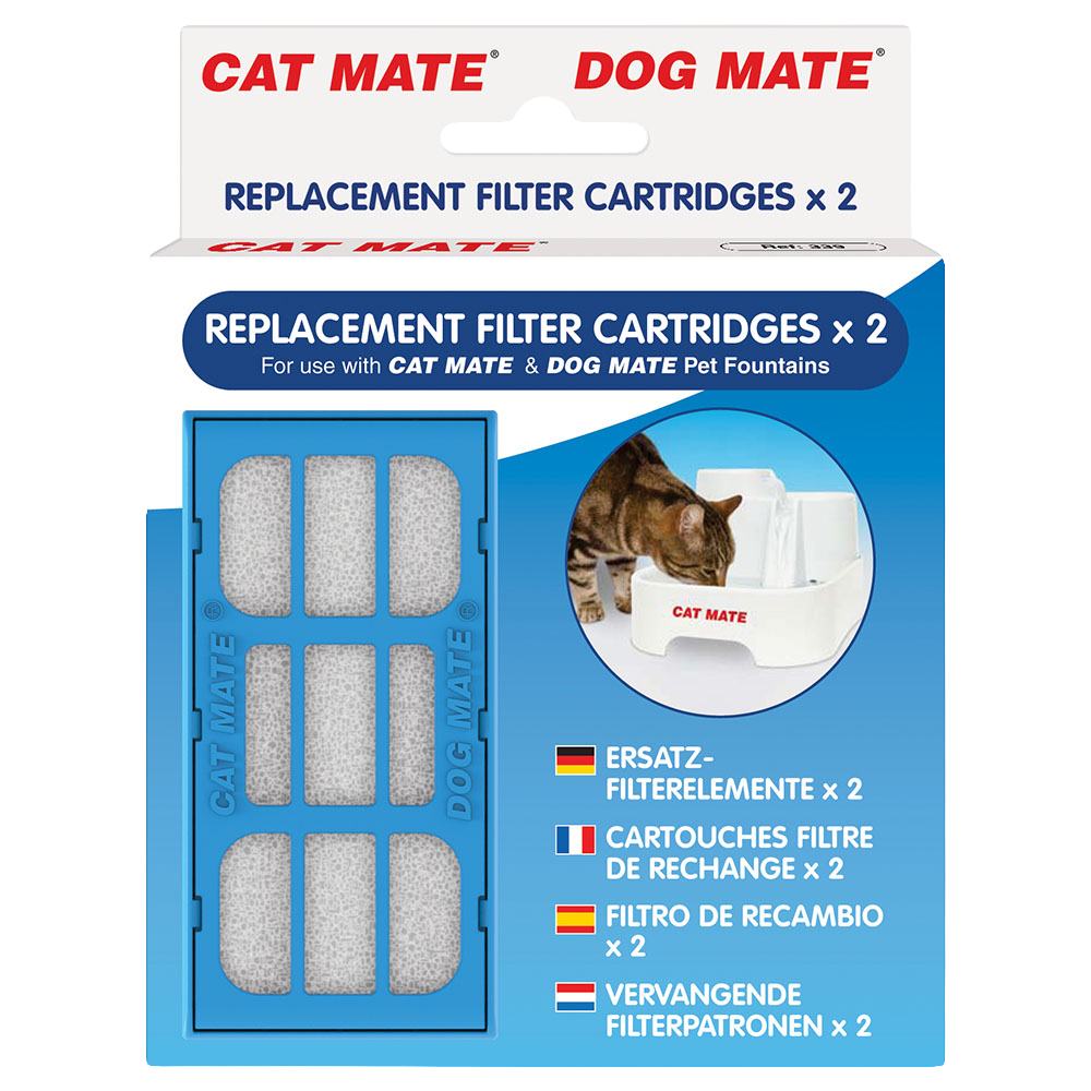 Product packaging for Cat Mate and Dog Mate replacement filter cartridges. The front of the box shows two filter cartridges inside a blue plastic casing, labelled for use with Cat Mate and Dog Mate pet fountains. A round image on the right side shows a tabby cat drinking from a white Cat Mate water fountain. The packaging text includes translations in German, French, Spanish, and Dutch, each stating that the box contains two replacement filter cartridges.