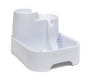 A side angle view showing the left hand side of the empty white pet drinking fountain on a white background 