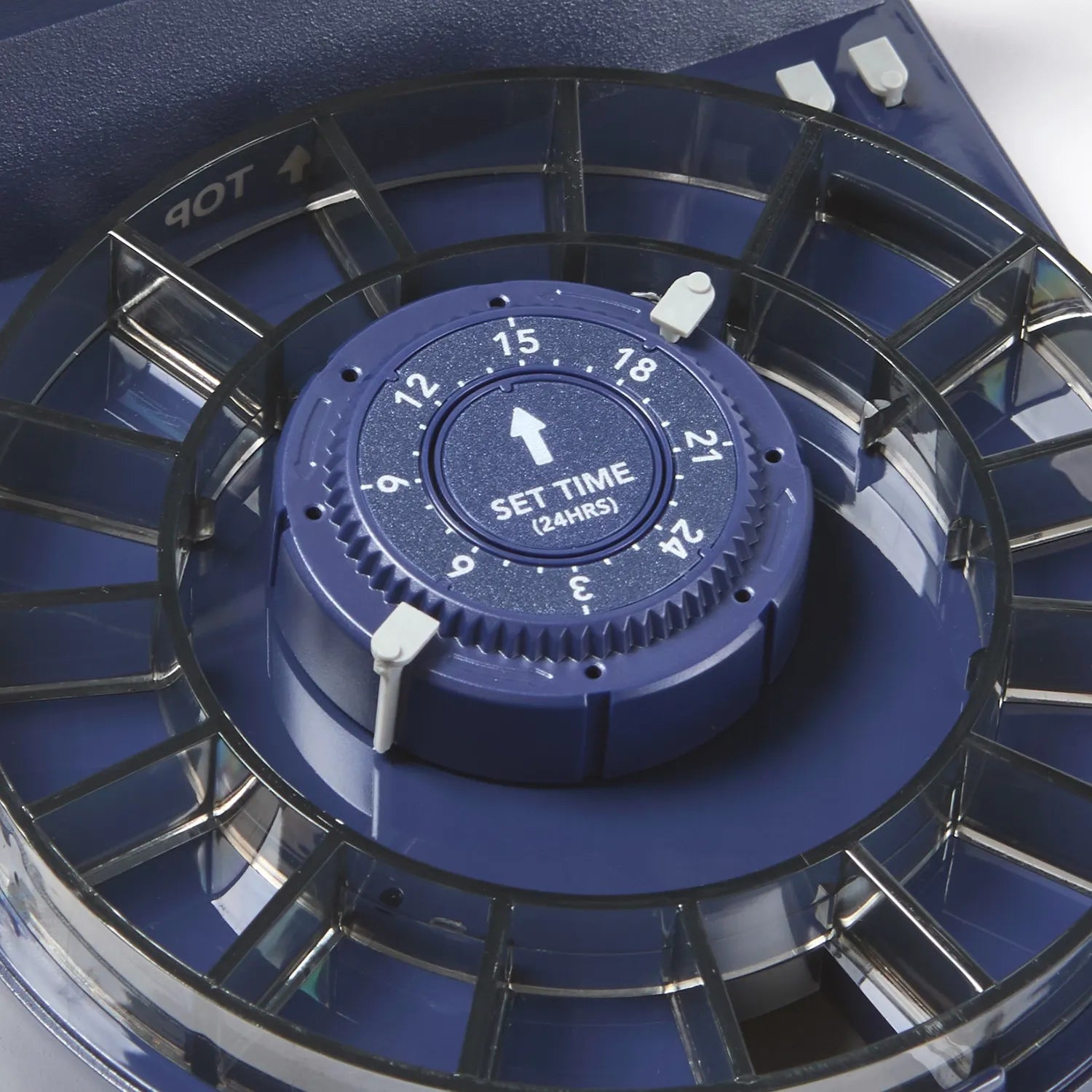 Close-up of a blue timer with dark coloured plastic feeding ring on a white background