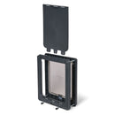 An angled view of the grey pet door for medium size dogs showing the manual locking panel positioned above the door to demonstrate its use 