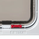 Close-up of the draft-proof brushing with a red clip mechanism and 'LOCK' label on the white lockable cat flap on a white background 