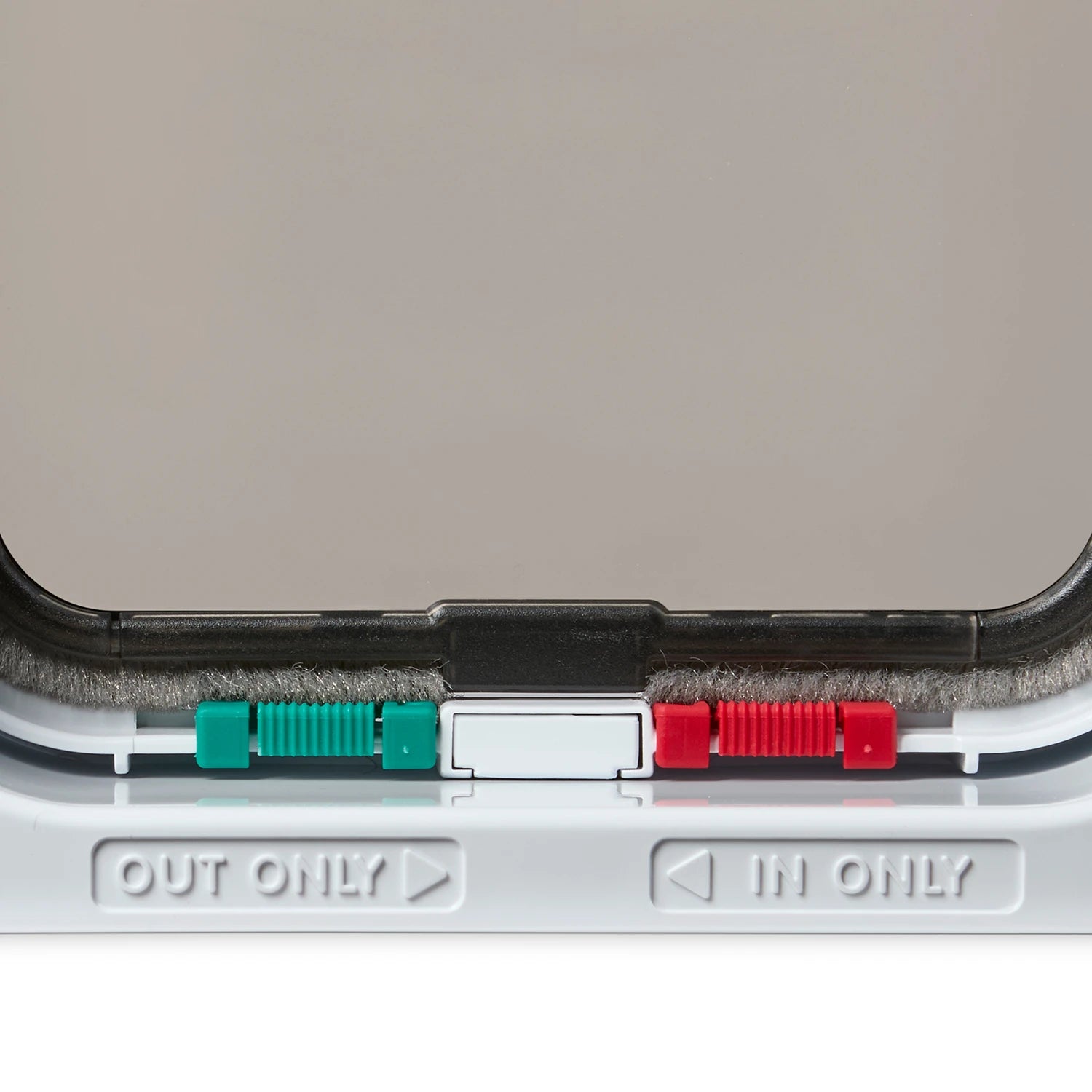 Close-up of a white cat flap with 'OUT ONLY' and 'IN ONLY' labels on a white background