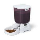 Pet food dispenser with a digital display and brown dry pet food filling the white bowl on a white background