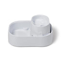 A side on view of an empty white pet water fountain on a white background 