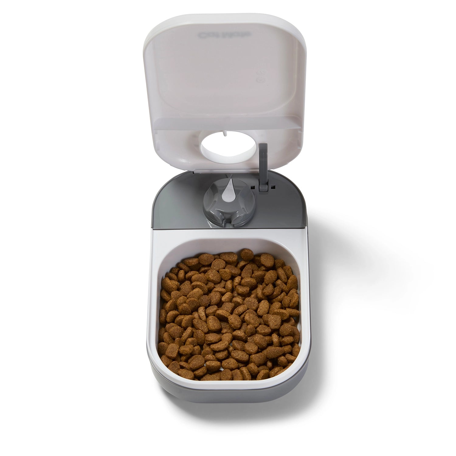 A grey and white automatic pet feeder for a cat or a small dog with dry pet food in it, on a white background 