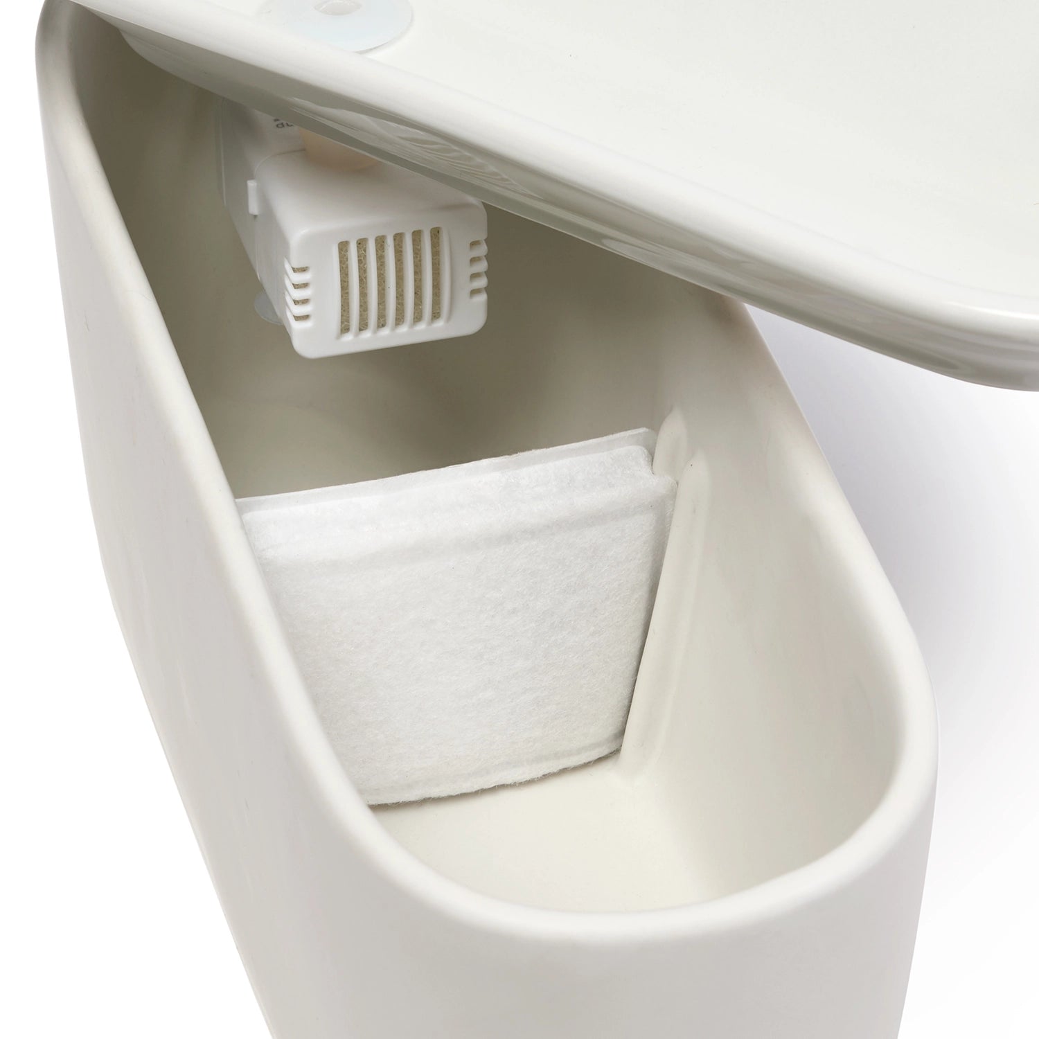 Interior view of a white Cat Mate ceramic pet drinking fountain showing the water reservoir compartment with a white filter cartridge and ventilation grille under the raised lid, with an 800ml capacity and USB lead. 