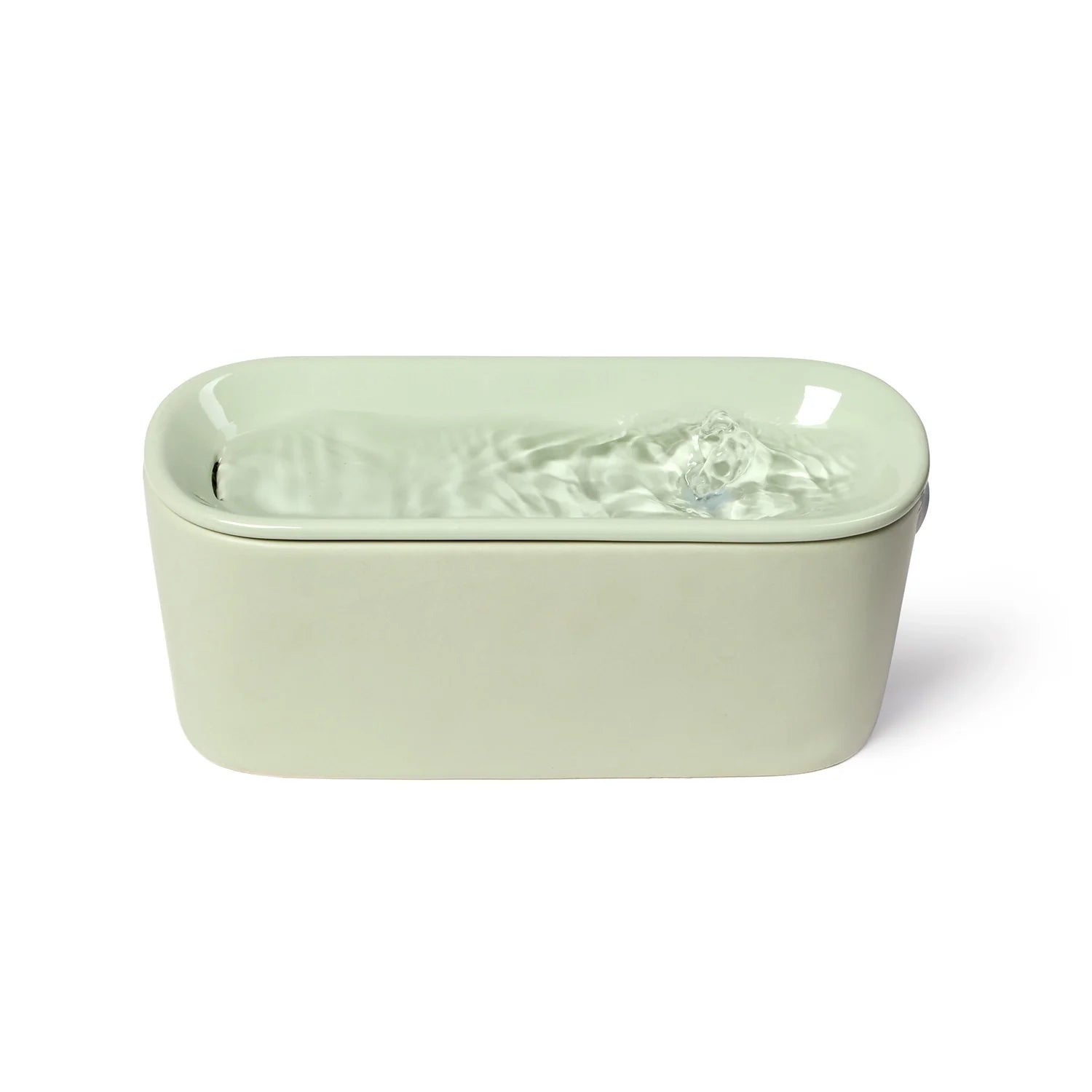 A sage green ceramic cat drinking fountain made by Cat Mate with a rounded rectangular shape, with water flowing from a small fountain spout, photographed against a white background.