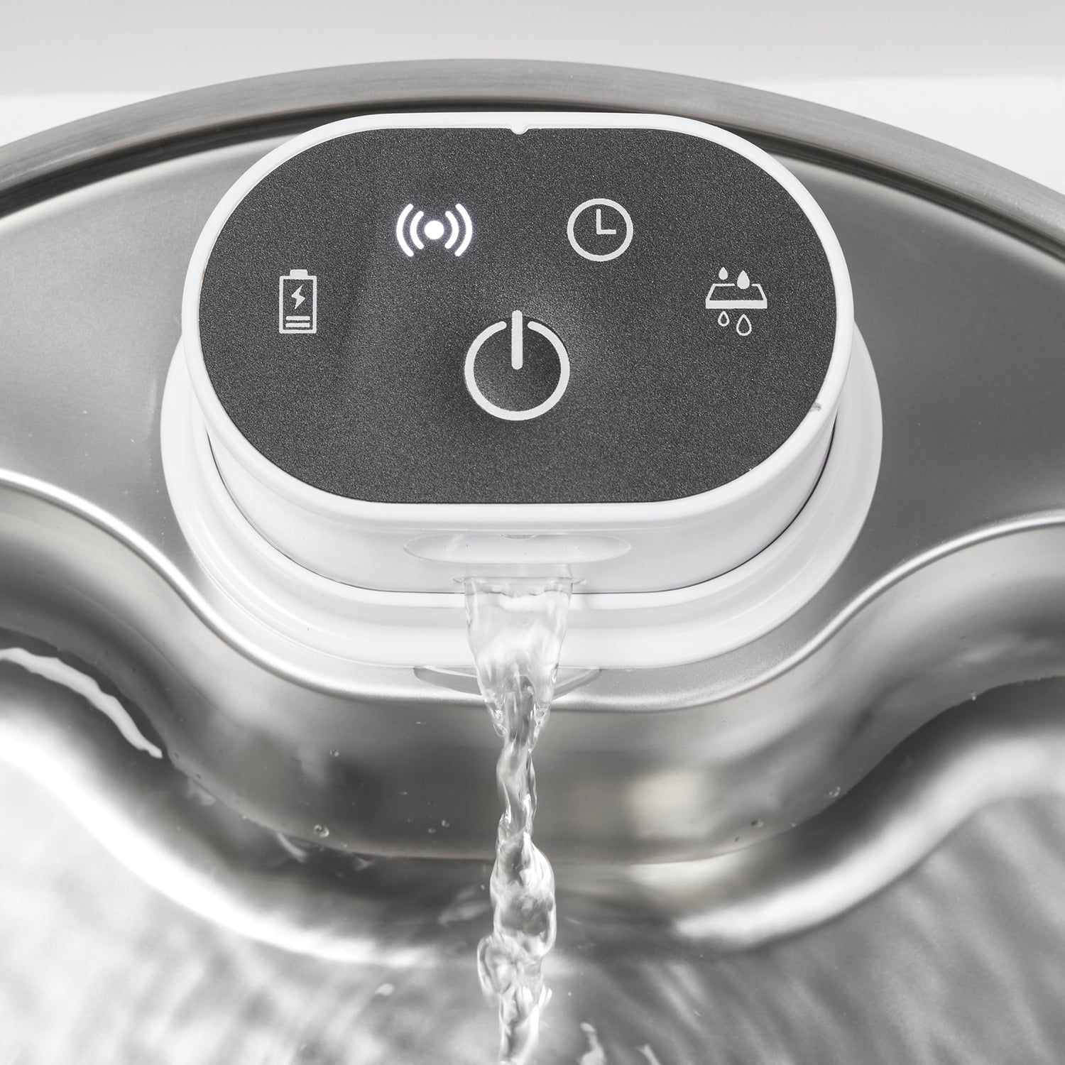 Close-up of the Cat Mate pet drinking fountain displaying the detail on the black control panel with white icons and water flowing into the shallow bowl beneath. 