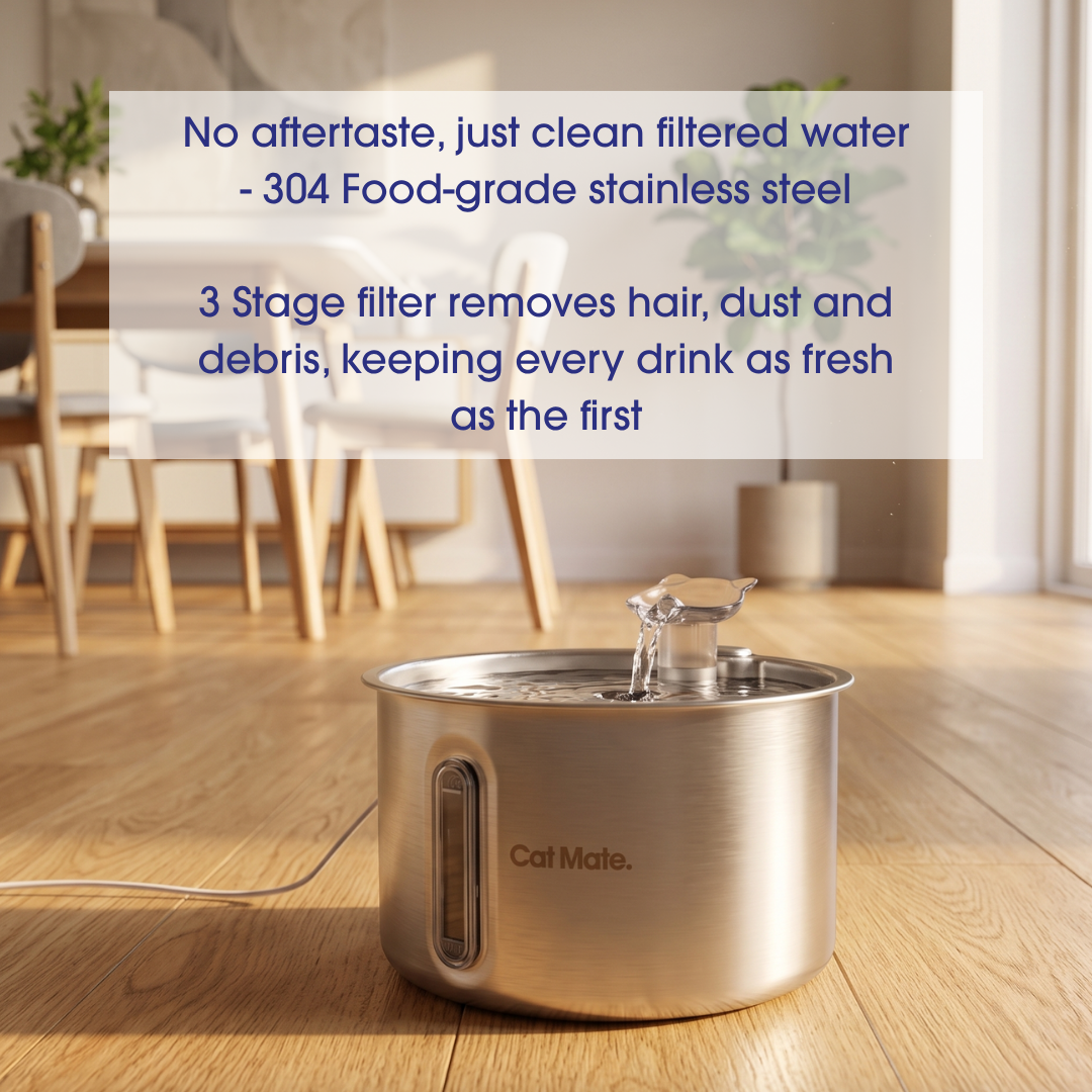 A stainless steel pet water fountain with an interchangeable spout filled with water sits on a wooden floor in a bright room. The fountain has an electriical cord to provide power.  Blue text on a semi-transparent white box at the top describes the product benefits, and the brand name Cal Male is visible on the front of the fountain.
